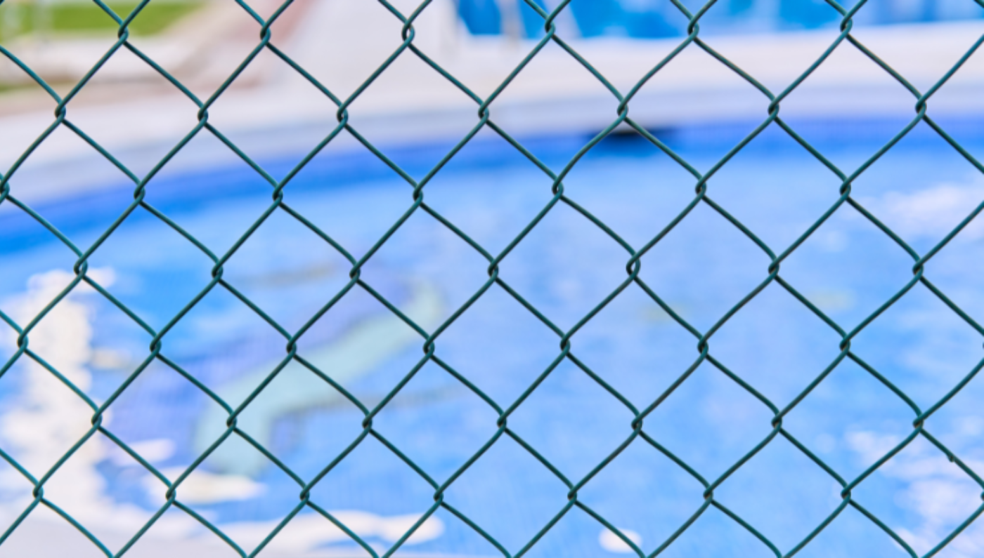 Generic image of a metal fence with a pool in the background