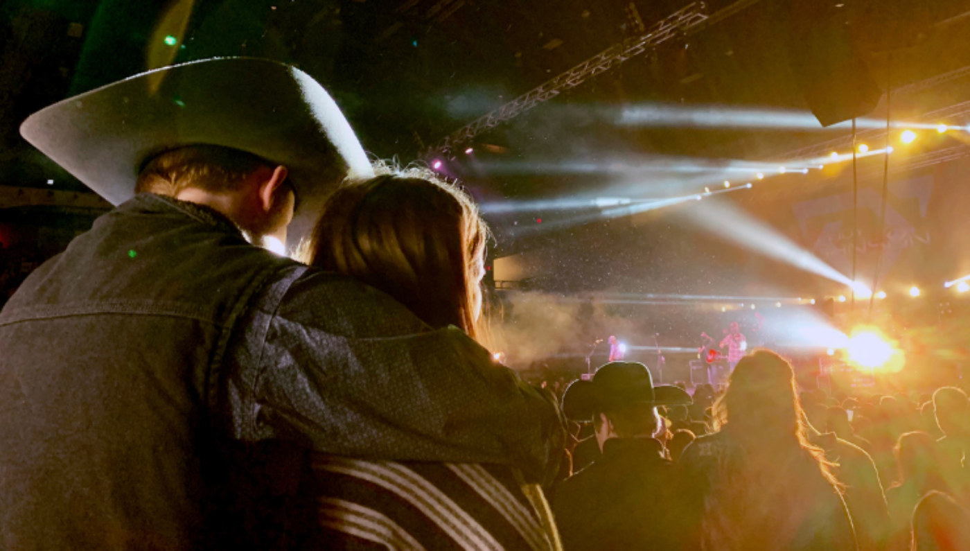 Photo d'un couple de dos dans le public d'un spectacle country